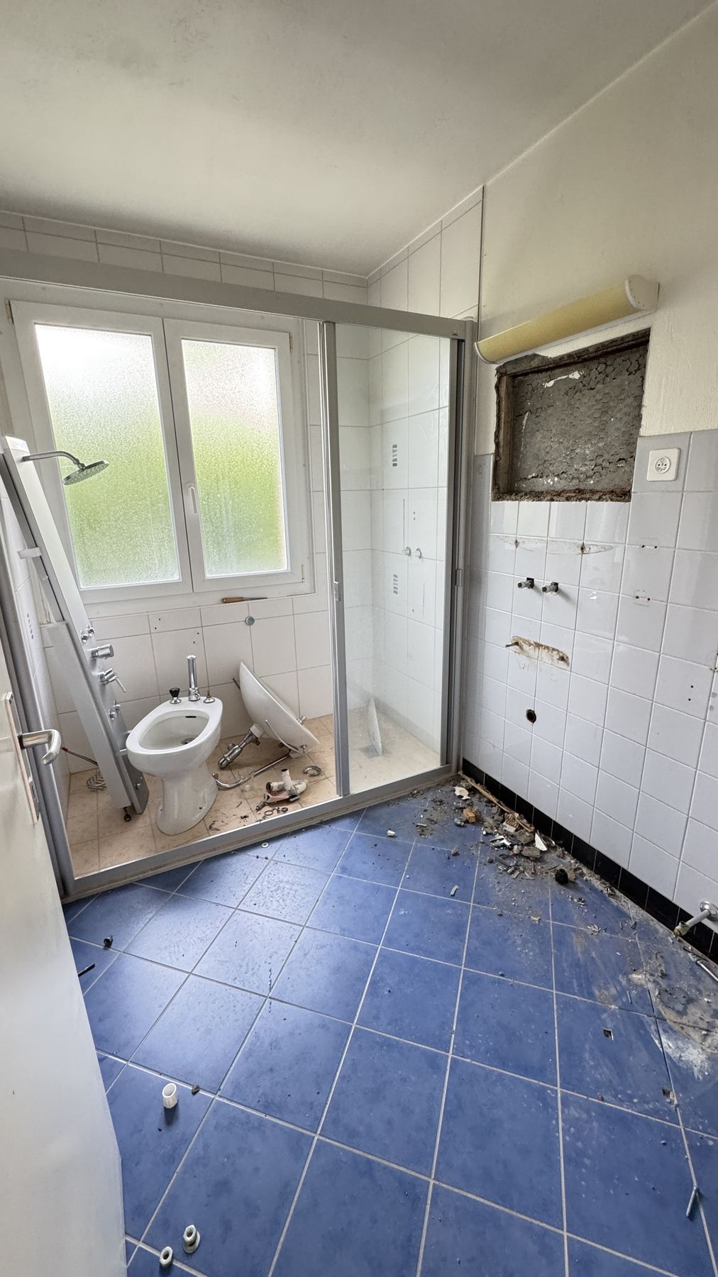 Ancienne salle de bain carrelée bleue avant rénovation - Neuchâtel