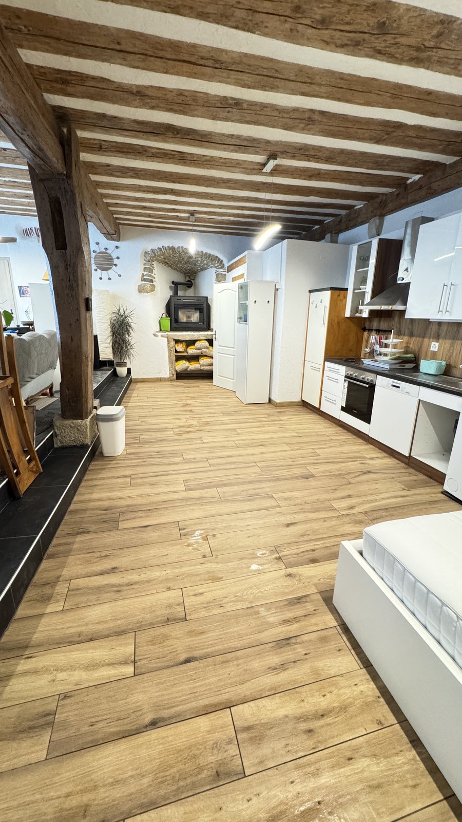 Pièce avec carrelage imitation bois et poutres rustiques - après